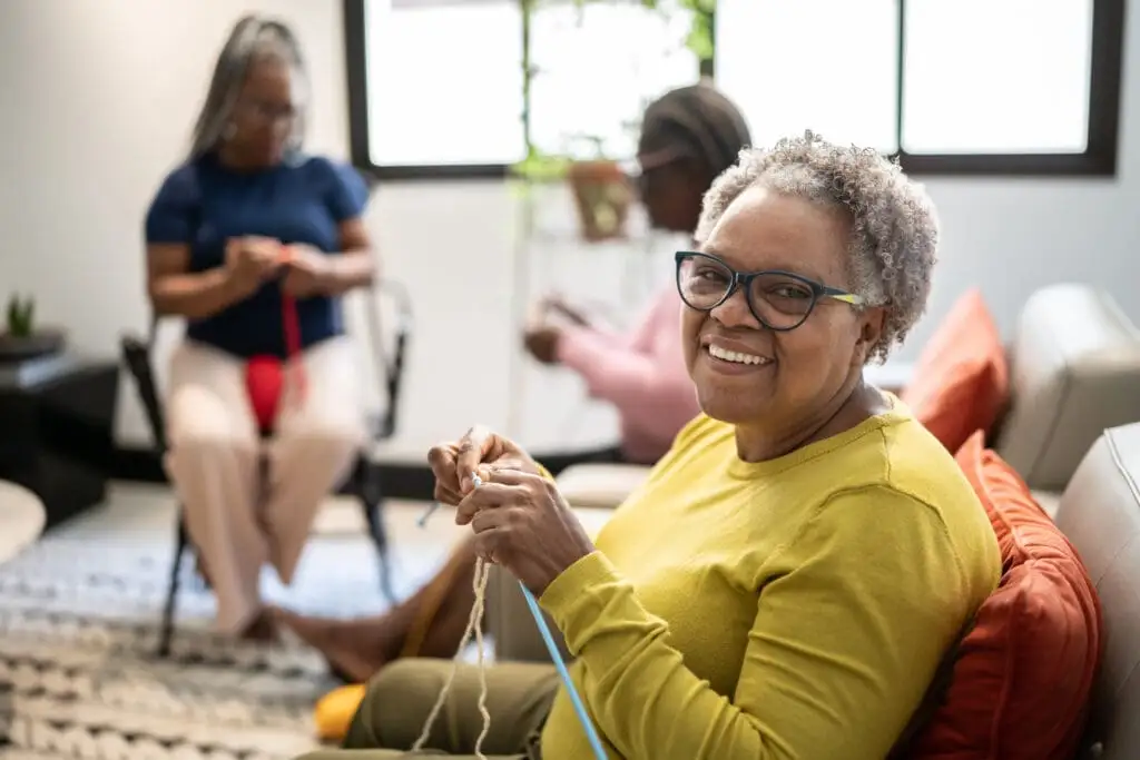 Three senior women in a knitting club. Knitting is a great activity for seniors with limited mobility in assisted living at Charter Senior Living of Bay City.
